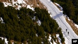 People make their way through a snow-covered landscape at the Nordkette Alps mountains in Innsbruck, Austria, Jan. 2, 2023.