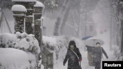 Warga berjalan di tengah hujan salju di Kanazawa, Prefektur Ishikawa, Jepang tengah, 23 Desember 2022. (Kyodo/via REUTERS)
