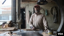 Mohammad Shafi Dar has been working with Model Sports Industries, a cricket bat manufacturing factory, for two decades. (Wasim Nabi/VOA)