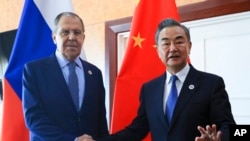 FILE - In this photo released by the Russian Foreign Ministry Press Service, Russian Foreign Minister Sergey Lavrov and Chinese Foreign Minister Wang Yi pose for a photo in Phnom Penh, Cambodia, on Aug. 5, 2022. 