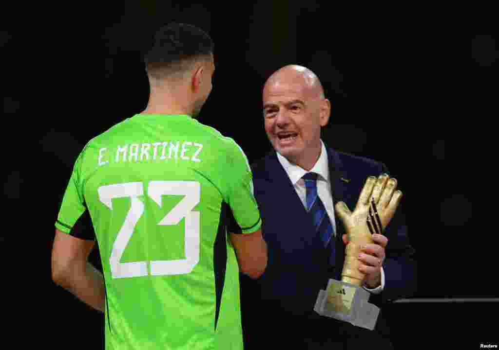 O presidente da FIFA, Gianni Infantino, entrega o troféu Luva de Ouro ao guarda-redes argentino Emiliano "Dibu" Martínez.