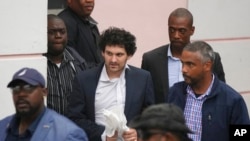 FTX founder Sam Bankman-Fried, center, is escorted from the Magistrate Court in Nassau, Bahamas, Dec. 21, 2022, after agreeing to be extradited to the U.S.