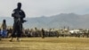 FILE - A Taliban security personnel stands guard as people attend to watch publicly flogging of women and men at a football stadium in Charikar city of Parwan province on Dec. 8, 2022.