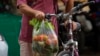 A shopper leaves a market on a bike in Havana, Dec. 23, 2022. 