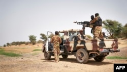 FILE - Malian army soldiers patrol an area next to the river of Djenne in central Mali, Feb. 28, 2020.