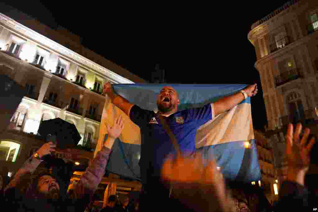 Os fãs argentinos celebram na Puerta del Sol, Madrid, Espanha, após o jogo de futebol meia-final do Campeonato do Mundo entre Argentina e Croácia no Qatar, terça-feira, 13 de Dezembro de 2022. A Argentina derrotou a Croácia por 3-0. (AP Photo/Andrea Comas)