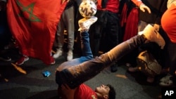 A Morocco fan kicks around a soccer ball during celebrations in Barcelona on Dec. 6, 2022. Morocco beat Spain on penalties in a round of 16 World Cup soccer match in Qatar.
