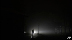 Una mujer camina por el centro de la ciudad que se quedó sin energía eléctrica después de un ataque con cohetes rusos en Kiev, Ucrania, el 24 de noviembre de 2022.