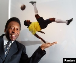Legenda sepak bola Brasil Pele berdiri di samping foto dirinya oleh Patrick Lichfield pada pembukaan 'Pele Collection' di County Hall, London, 9 Oktober 2003. (Foto: Reuters)