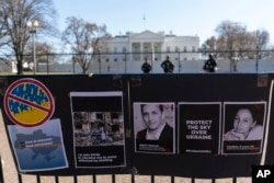 FILE - Signs and pictures of those killed, including journalist Brent Renaud, are displayed on a fence during a protest against Russia's invasion of Ukraine in Lafayette Park near the White House, March 13, 2022, in Washington.