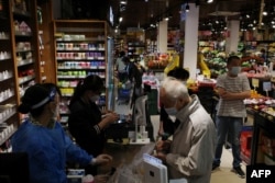 Warga berbelanja di supermarket di distrik Haizhu, kota Guangzhou, provinsi Guangdong selatan China, menyusul pelonggaran pembatasan COVID-19 di kota tersebut, 30 November 2022.(Foto oleh CNS / AFP)