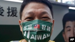 A supporter wears a mask with the Taiwan national flag and slogan reading 'Taiwan is awesome' during an election campaign in Taipei, Nov. 20, 2022. 