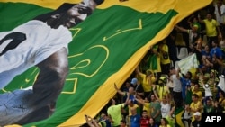 A large flag of Brazil legend Pele is unveiled in the crowd ahead of the Qatar 2022 World Cup Group G football match between Cameroon and Brazil at the Lusail Stadium in Lusail, north of Doha on Dec. 2, 2022