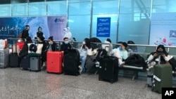 FILE - Masked travelers are seen in a waiting area at Guangzhou Baiyun Airport in China's southern Guangdong province, Dec. 25 2022. 