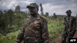 Janvier Karairi, left, 60, self-proclaimed lieutenant general of the Alliance of Patriots for a Free and Sovereign Congo militia, patrols near Kitshanga in the east of the Democratic Republic of the Congo on Dec. 11, 2022.