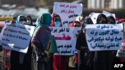 Women hold placards during a protest calling for their rights to be recognized, near the Shah-e-Do Shamshira mosque in Kabul, Nov. 24, 2022.