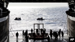 Miembros de la Marina de EEUU lanzan un bote pequeño como parte de la operación de recuperación de la cápsula Orion de la NASA en el Pacífico frente a México, el domingo 11 de diciembre de 2022.