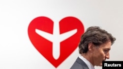 Perdana Menteri Kanada Justin Trudeau berjalan melewati sebuah karya seni dalam sebuah pameran seni di Toronto, Ontario, Kanada, pada 8 Januari 2023. (Foto: Reuters/Carlos Osorio)