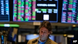 FILE - Traders work on the floor at the New York Stock Exchange in New York, Monday, Nov. 28, 2022.