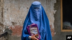 FILE - Arefeh, 40, an Afghan woman, leaves an underground school in Kabul, July 30, 2022. She attends this school with her daughter, who like other teenage girls is not allowed to go to public school.