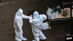 Security guards are seen at the entrance of a compound under COVID-19 lockdown in the Jing'an district in Shanghai on Dec. 3, 2022. 