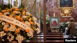 A person pays homage in front of a photo of former Pope Benedict, at the Apostolic Nunciature, or the Vatican's embassy, in Madrid, Spain, Jan. 3, 2023. 