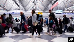 Travelers walk through Terminal 3 at O'Hare International Airport in Chicago, Dec. 22, 2022.
