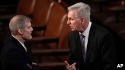 Rep. Jim Jordan, left, talks with Rep. Kevin McCarthy in the House chamber as the House meets for a second day to elect a speaker and convene the 118th Congress in Washington, Jan. 4, 2023.