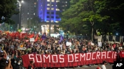 Demonstrators march holding a banner that reads in Portuguese "We are Democracy" during a protest calling for protection of the nation's democracy in Sao Paulo, Brazil, Jan. 9, 2023.