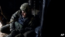 A Ukrainian soldier sits in his position during fights with Russian forces near Maryinka, Donetsk region, Ukraine, Dec. 23, 2022. 