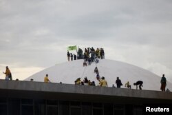 Los partidarios del expresidente de Brasil, Jair Bolsonaro, en la parte superior de la cúpula del Congreso Nacional durante una manifestación contra el presidente Luiz Inácio Lula da Silva, en Brasilia, Brasil, el 8 de enero de 2023.