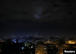 Ukrainian servicemen use searchlights as they search for drones in a sky over city during a Russian drones strike in Kyiv, Jan. 1, 2023.