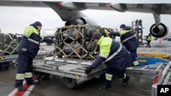 FILE - Workers unload a shipment of military aid delivered as part of the United States of America's security assistance to Ukraine, at the Boryspil airport, outside Kyiv, Ukraine, Feb. 11, 2022.