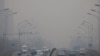 Kabut asap tampak melingkupi langit Kota Beijing, China, di tengah kendaraan yang lalu lalang di kota tersebut pada 13 Februari 2021. (Foto: Reuters/Carlos Garcia)
