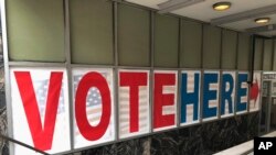 A 'Vote Here' sign marks the entrance on Sept. 20, 2018, to an early voting station in downtown Minneapolis.