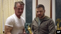 En esta foto divulgada por la oficina de la Presidencia de Ucrania, el presidente ucraniano Volodomyr Zelenskyy sostiene la estatuilla del Oscar junto al actor estadounidense Sean Penn.
