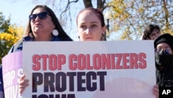 Demonstrators stand outside the U.S. Supreme Court as the court hears arguments over the Indian Child Welfare Act, Nov. 9, 2022, in Washington.