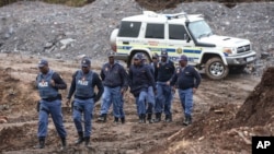 South African police investigate at the scene where more 21 bodies of suspected illegal miners were found near an active mine in Krugersdorp, South Africa, Nov. 3, 2022.