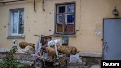 Belongings are collected on a trolley put near a house damaged by Russian shelling, in Siversk, Donetsk region, Ukraine, Nov. 6, 2022.