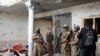 Taliban fighters inspect a house after an eight-hour gun battle between Taliban and Islamic State group fighters at a suspected ISIS hideout on the outskirts of Jalalabad, east of Kabul, on November 30, 2021. (Shir Shah Hamdard/Associated Press)