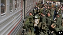 FILE - Russian recruits board a train at a railway station in Prudboi, in Russia's Volgograd region, Sept. 29, 2022.