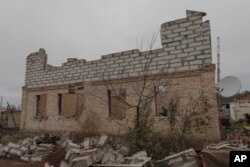 Vadym Zherdetsky stands in the remains of his house destroyed by fighting, in the village of Moshun, outside Kyiv, Ukraine, Friday, Nov. 4, 2022.
