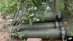 FILE - U.S.-supplied M777 howitzer shells lie on the ground to fire at Russian positions in Ukraine's eastern Donbas region, June 18, 2022. The writing on one of them reads in Ukrainian: "Nothing is forgotten."