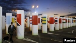 A participant arrives during sunset at the World Climate Change Conference 2015 (COP21) at Le Bourget, near Paris, Dec. 6, 2015.