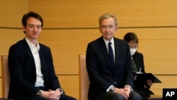 เฟรเดอริก อาร์โนลต์ (ซ้าย) และบิดา เบอร์นาร์ด ขณะรอตัวเเทนจากรัฐบาลญี่ปุ่นที่กรุงโตเกียว 2 พ.ค. 2022