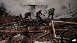 Firefighters work to extinguish a fire after a Russian attack destroyed the building of a Culinary School in Kharkiv, Apr. 12, 2022. 