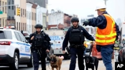 FILE - Officers with bomb-sniffing dogs look over the area after a shooting on a subway train, April. 12, 2022, in the Brooklyn borough of New York.