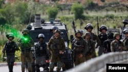 Pasukan Israel berjaga dalam aksi protes menyusul tewasnya warga Palestina Mohammed Ghoneim, yang menurut pihak medis dibunuh oleh pasukan Israel, di dekat Bethlehem, Tepi Barat, pada 11 April 2022. (Foto: Reuters/Mussa Qawasma)