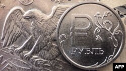 FILE - A Russian ruble coin is pictured with U.S. currency in Moscow, March 15, 2022.