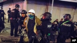 FILE - In this May 31, 2020, photo, police officers arrest a demonstrator in Los Angeles where Police Department is investigating 56 allegations of misconduct during protests against police brutality in the wake of George Floyd's death. 